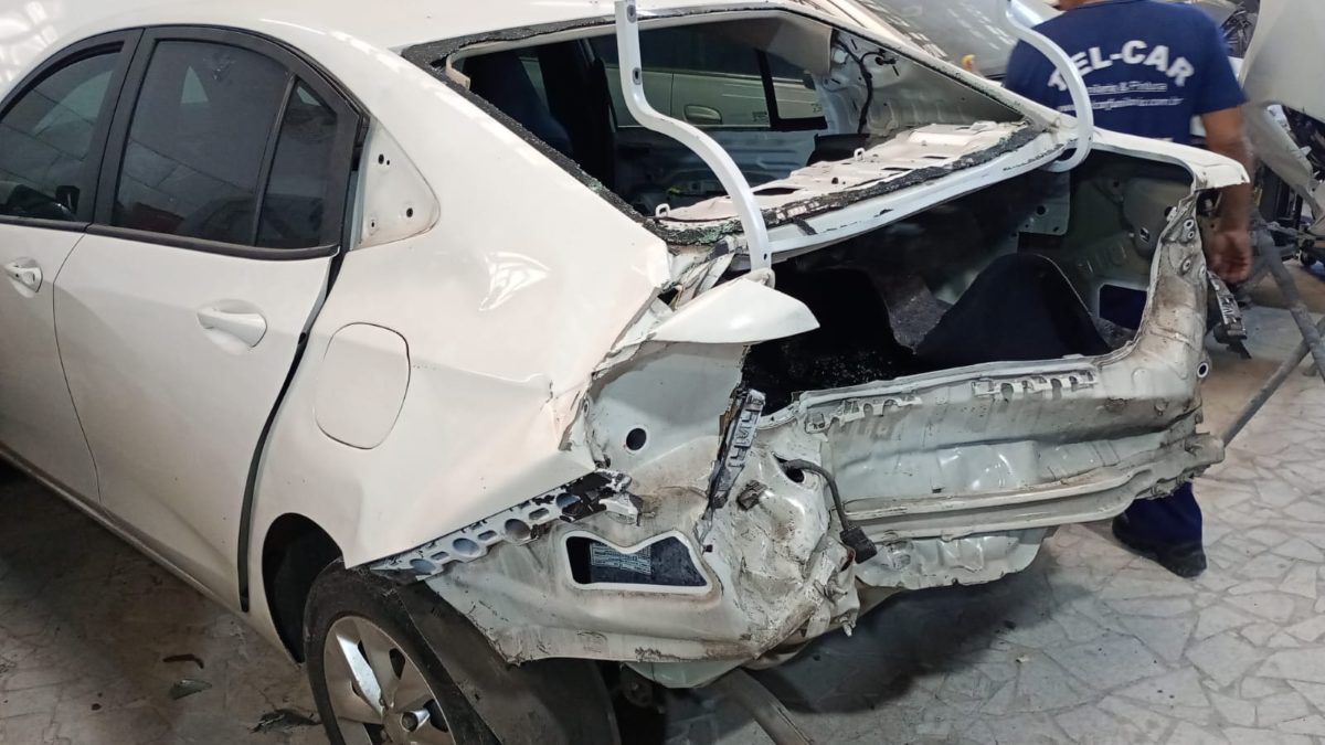Traseira do mesmo veículo com dano estrutural de sinistro, antes do reparo